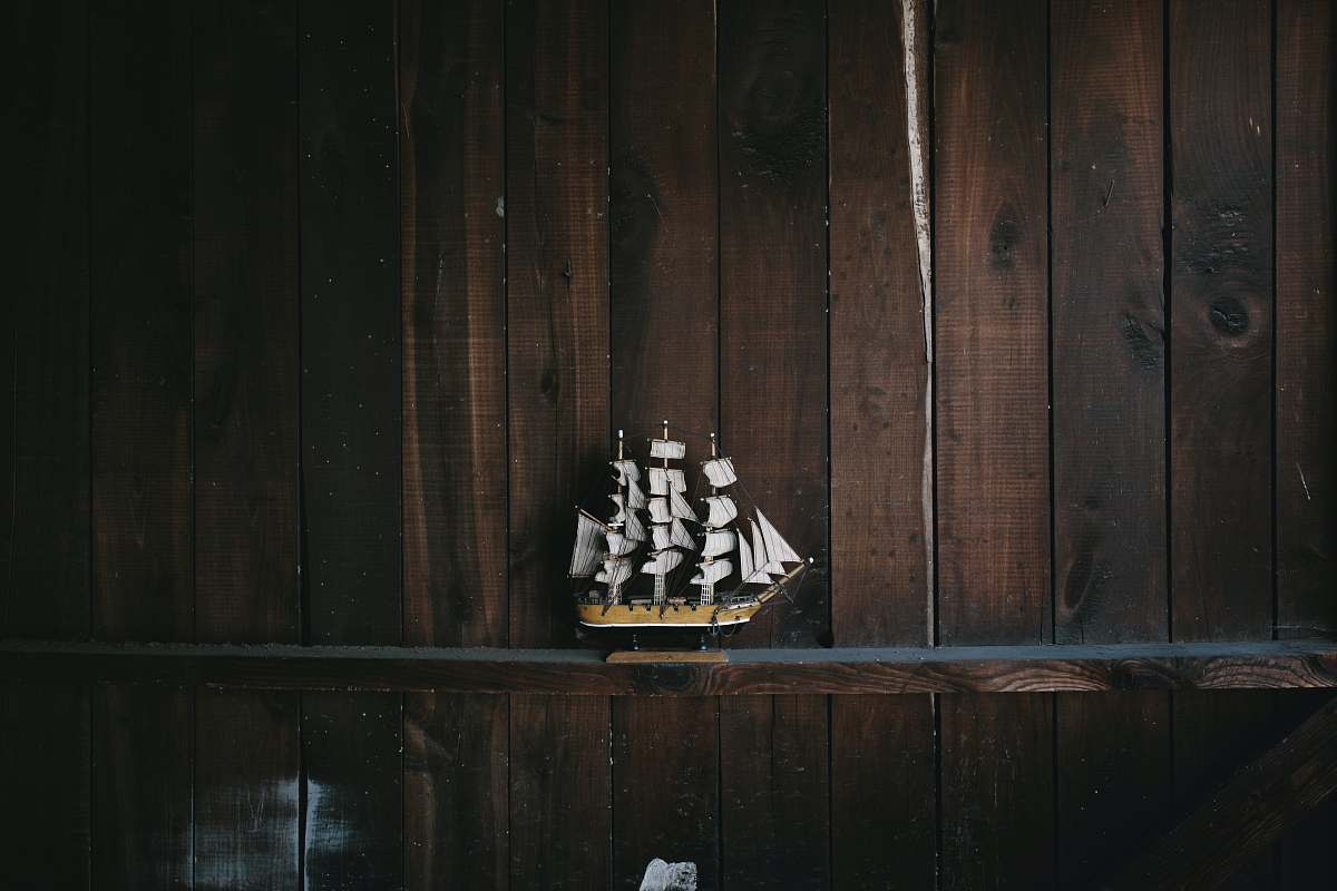 greensboro black, brown, and white galleon ship scale model on brown wooden shelf nautical